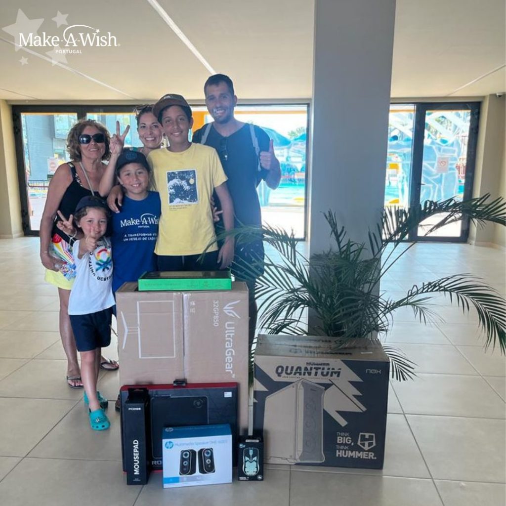 Miguel Caeiro e a família, todos a sorrirem com o set up gaming em caixas embrulhadas com o papel de embrulho da Make-A-Wish 